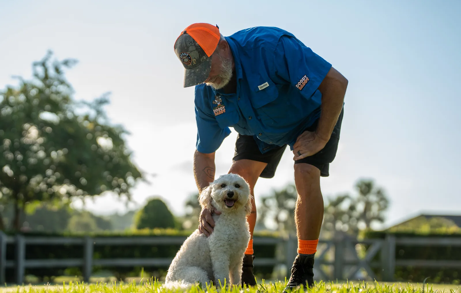Doody Daddy technician removing pet waste from a fenced backyard in St. Johns, Florida